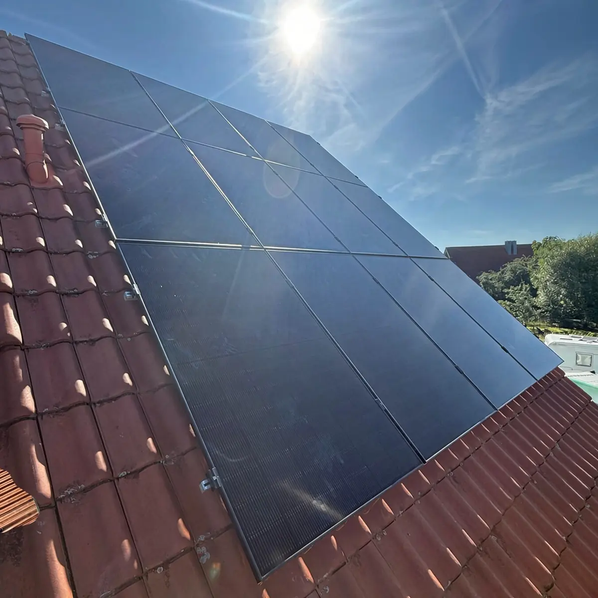 Crni solarni paneli na krovu prekrivenom crijepom, u sunčanom danu